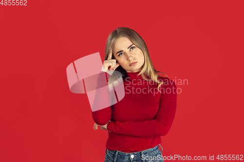 Image of Monochrome portrait of young caucasian blonde woman on red background