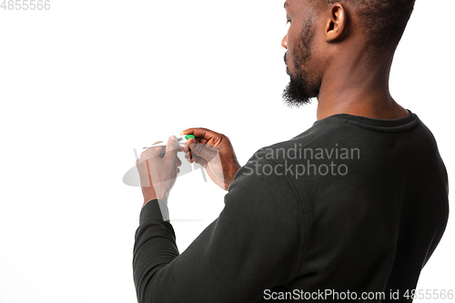 Image of How coronavirus changed our lives. Young man checking, taking temperature on white background