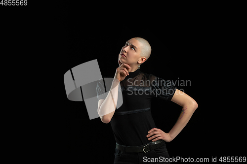 Image of Monochrome portrait of young caucasian bald woman on black background