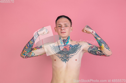 Image of Portrait of young man with freaky appearance on pink background