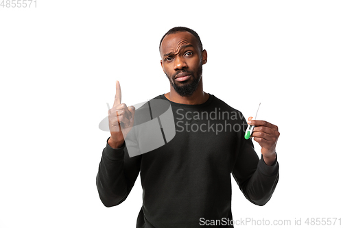 Image of How coronavirus changed our lives. Young man checking, taking temperature on white background