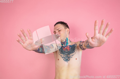 Image of Portrait of young man with freaky appearance on pink background