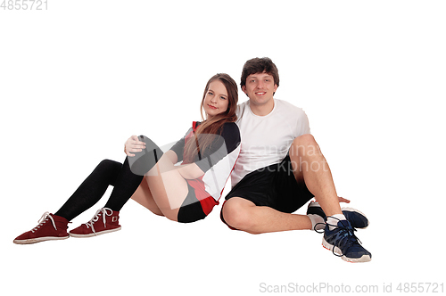 Image of Couple sitting in sportswear on the floor