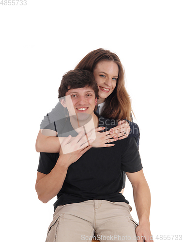 Image of Young couple, she is hugging him from behind