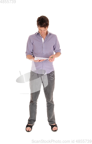 Image of Young Caucasian man standing and reading