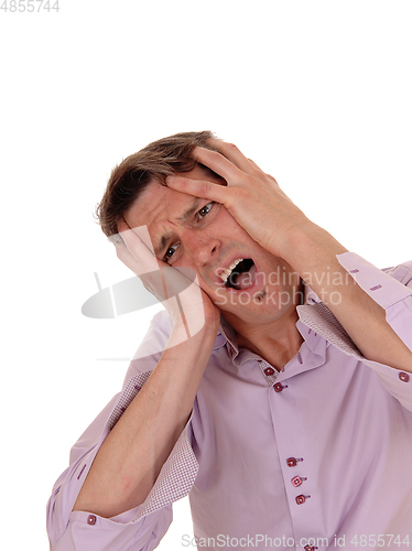 Image of Crying young man with hands on face