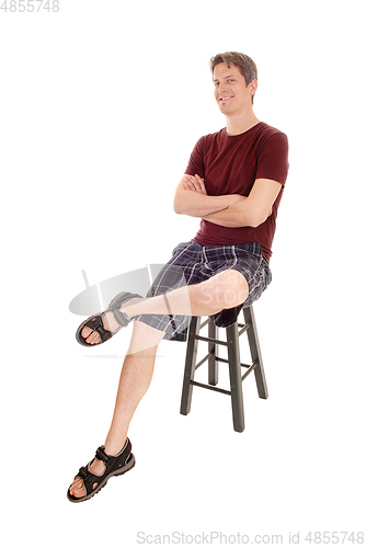 Image of Happy man sitting on a chair smiling
