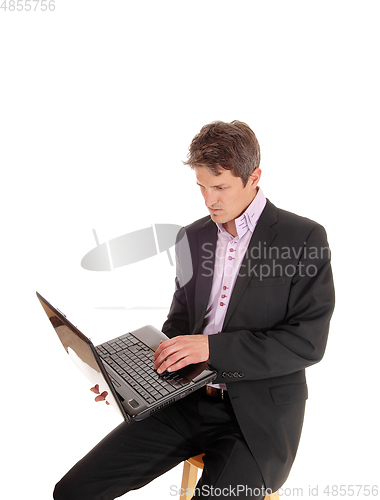 Image of Business man sitting and working on his laptop