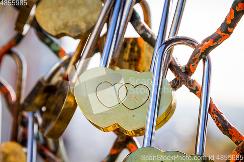 Image of Padlocks symbols of love hanging on a fence