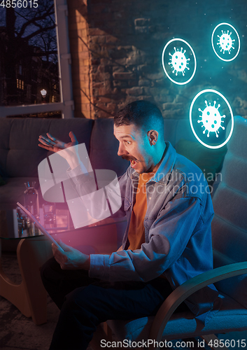 Image of Shocked, upset and sad man using gadgets to get information of coronavirus pandemic spread