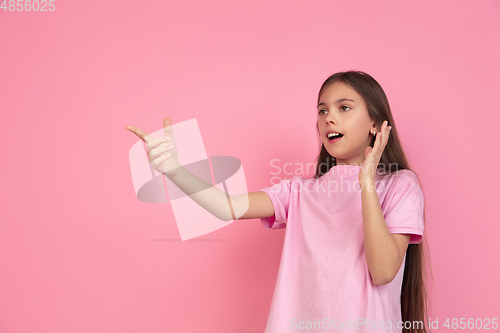 Image of Caucasian little girl portrait isolated on pink studio background, emotions concept