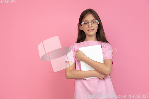 Image of Caucasian little girl portrait isolated on pink studio background, emotions concept