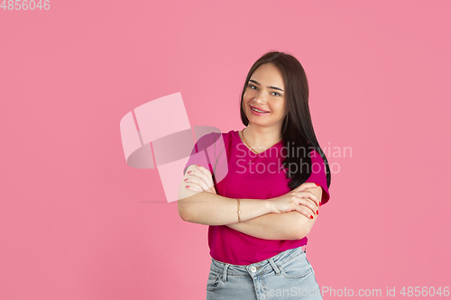 Image of Monochrome portrait of young caucasian brunette woman on pink background