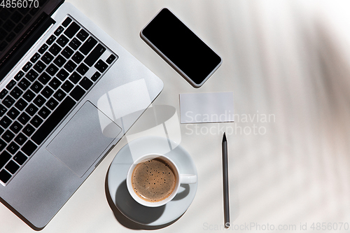 Image of Creative and cozy workplace at home office, inspirational mock up with plant shadows on table surface