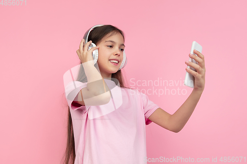 Image of Caucasian little girl portrait isolated on pink studio background, emotions concept