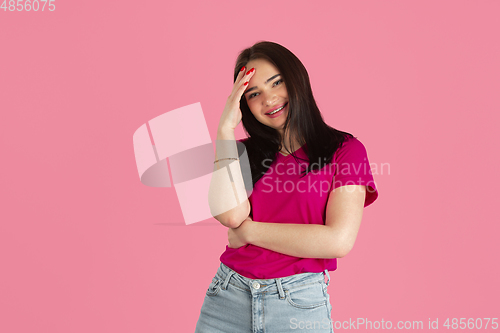 Image of Monochrome portrait of young caucasian brunette woman on pink background