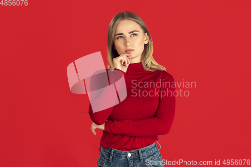Image of Monochrome portrait of young caucasian blonde woman on red background
