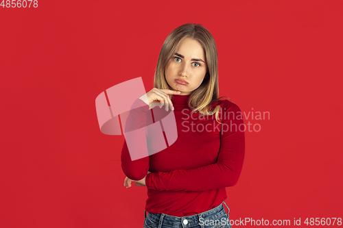 Image of Monochrome portrait of young caucasian blonde woman on red background