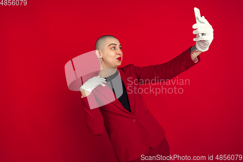 Image of Portrait of young caucasian bald woman on red background