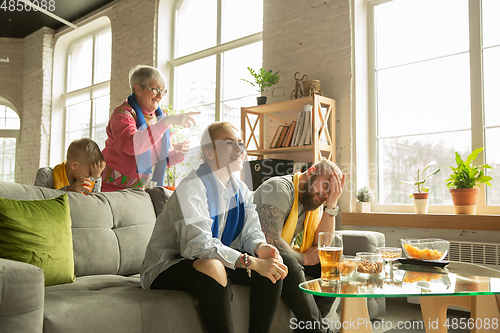 Image of Excited family watching football, sport match at home, top view