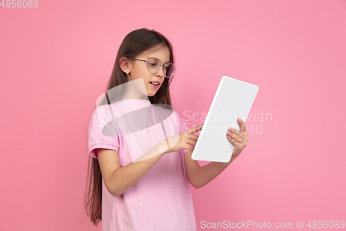 Image of Caucasian little girl portrait isolated on pink studio background, emotions concept