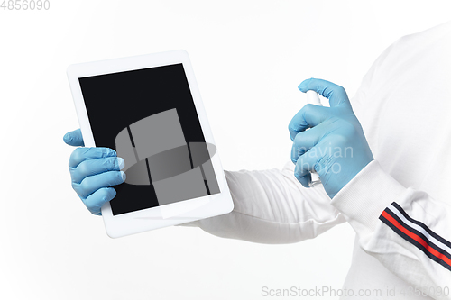 Image of How coronavirus changed our lives. Young man disinfecting gadgets surfaces on white background