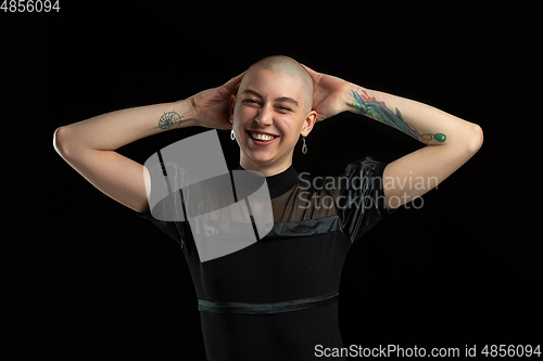 Image of Monochrome portrait of young caucasian bald woman on black background