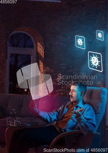 Image of Shocked, upset and sad man using gadgets to get information of coronavirus pandemic spread