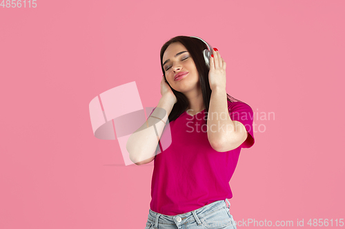 Image of Monochrome portrait of young caucasian brunette woman on pink background