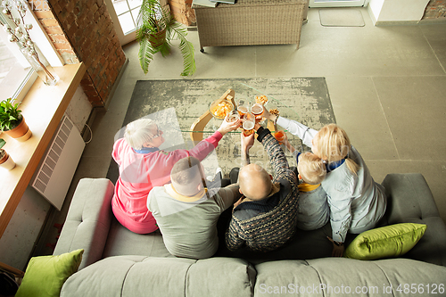 Image of Excited family watching football, sport match at home, top view
