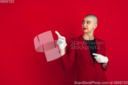 Image of Portrait of young caucasian bald woman on red background