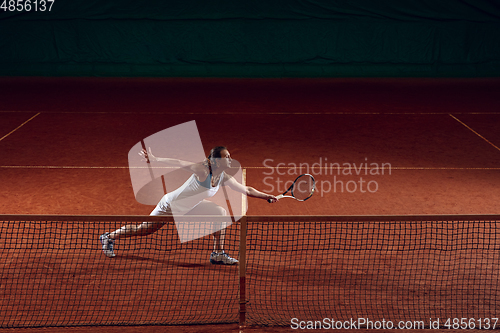 Image of Young caucasian professional sportswoman playing tennis on sport court background