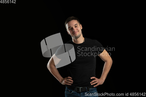 Image of Monochrome portrait of young caucasian man on black studio background