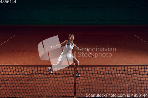 Image of Young caucasian professional sportswoman playing tennis on sport court background