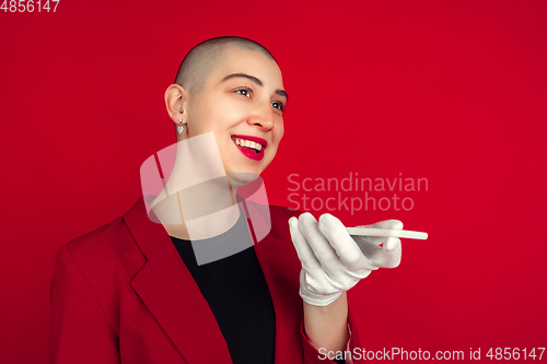 Image of Portrait of young caucasian bald woman on red background