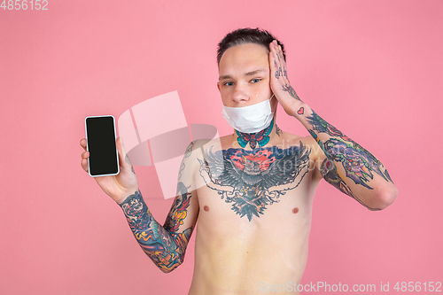 Image of Portrait of young man with freaky appearance on pink background