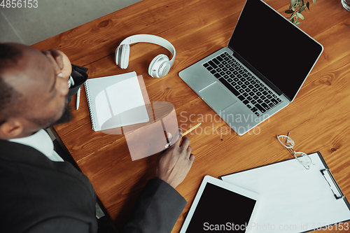Image of Top view of businessman or student working from home while being isolated or keep quarantine \'cause of coronavirus COVID-19