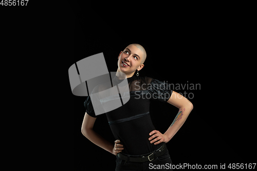 Image of Monochrome portrait of young caucasian bald woman on black background