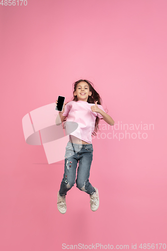 Image of Caucasian little girl portrait isolated on pink studio background, emotions concept