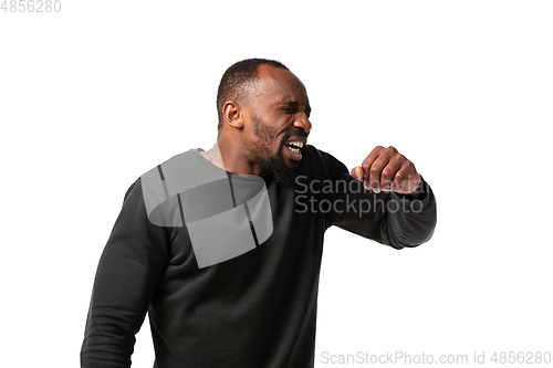Image of How coronavirus changed our lives. Young man sneezing on white background