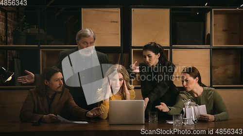 Image of Young colleagues working together in a office styled like classical artworks. Look busy, attented, cheerful, successful. Concept of business, office, finance.