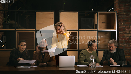 Image of Young colleagues working together in a office styled like classical artworks. Look busy, attented, cheerful, successful. Concept of business, office, finance.