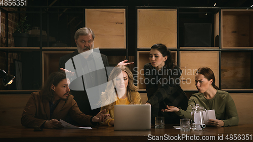 Image of Young colleagues working together in a office styled like classical artworks. Look busy, attented, cheerful, successful. Concept of business, office, finance.