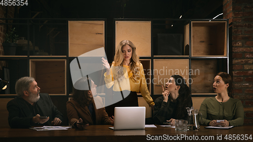 Image of Young colleagues working together in a office styled like classical artworks. Look busy, attented, cheerful, successful. Concept of business, office, finance.