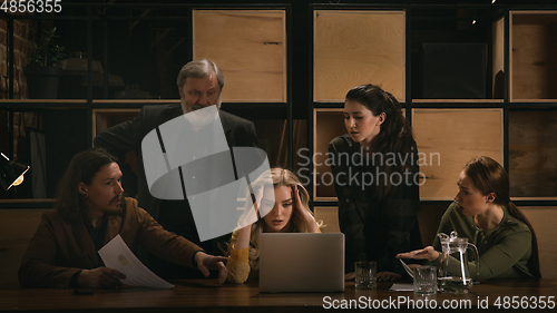 Image of Young colleagues working together in a office styled like classical artworks. Look busy, attented, cheerful, successful. Concept of business, office, finance.