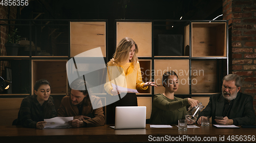 Image of Young colleagues working together in a office styled like classical artworks. Look busy, attented, cheerful, successful. Concept of business, office, finance.