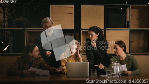 Image of Young colleagues working together in a office styled like classical artworks. Look busy, attented, cheerful, successful. Concept of business, office, finance.
