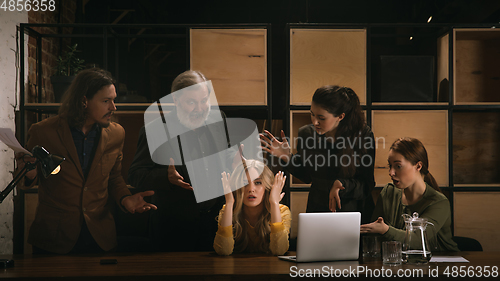 Image of Young colleagues working together in a office styled like classical artworks. Look busy, attented, cheerful, successful. Concept of business, office, finance.