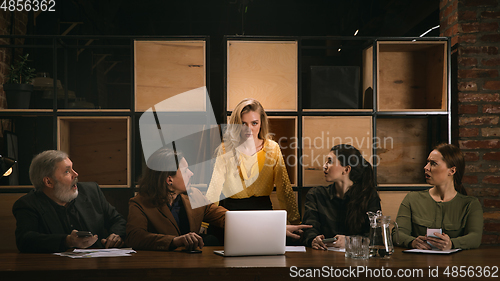 Image of Young colleagues working together in a office styled like classical artworks. Look busy, attented, cheerful, successful. Concept of business, office, finance.