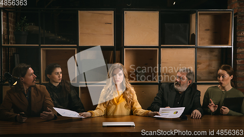 Image of Young colleagues working together in a office styled like classical artworks. Look busy, attented, cheerful, successful. Concept of business, office, finance.